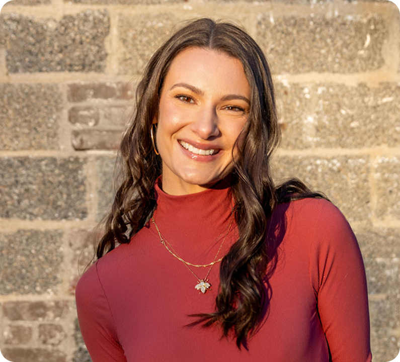 Cosmic Counseling’s Chelsea Alban, photographed against a stone wall, offering soul-centered therapy and astrological guidance